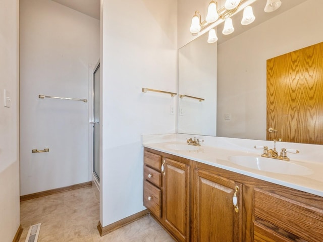 2117 W 4th Ave, Indianola, IA 50125 - full bathroom with double vanity, baseboards, and a shower with shower door