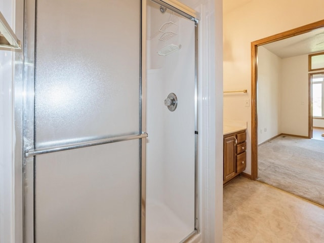 2117 W 4th Ave, Indianola, IA 50125 - bathroom featuring a stall shower, vanity, and baseboards