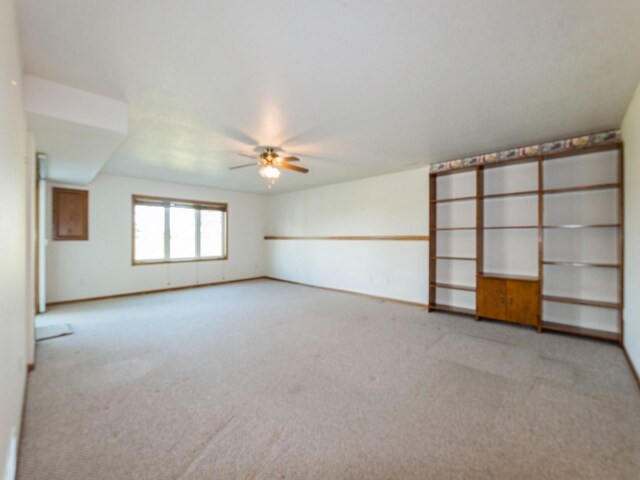 2117 W 4th Ave, Indianola, IA 50125 - spare room with light colored carpet, a ceiling fan, and baseboards