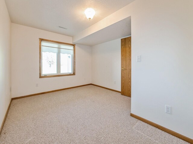 2117 W 4th Ave, Indianola, IA 50125 - spare room with carpet flooring, baseboards, and a textured ceiling