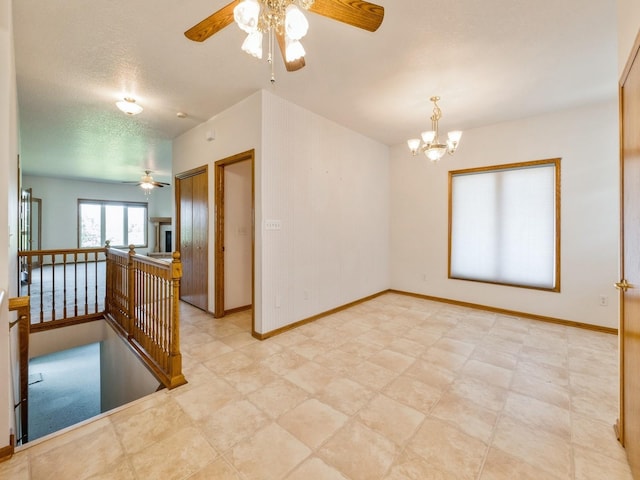 2117 W 4th Ave, Indianola, IA 50125 - spare room featuring ceiling fan, a chandelier, baseboards, and light floors