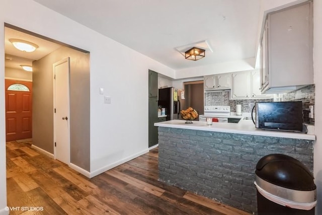 4305 65th St, Urbandale, IA 50322 - kitchen with white range with electric cooktop, stainless steel fridge, a peninsula, dark wood-style flooring, and light countertops