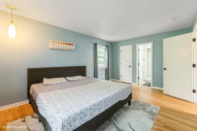4305 65th St, Urbandale, IA 50322 - bedroom with wood finished floors, baseboards, and connected bathroom