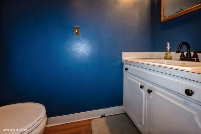 4305 65th St, Urbandale, IA 50322 - bathroom featuring baseboards, vanity, toilet, and wood finished floors