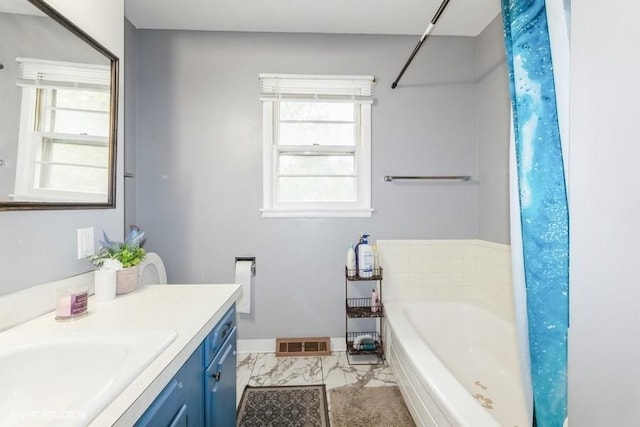 4305 65th St, Urbandale, IA 50322 - bathroom featuring vanity, a garden tub, healthy amount of natural light, and baseboards