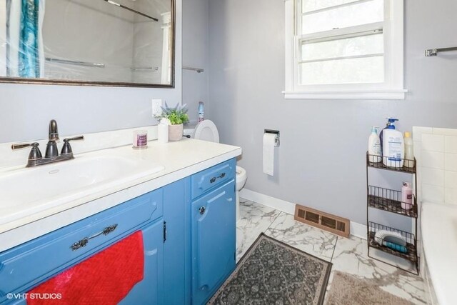 4305 65th St, Urbandale, IA 50322 - full bath with marble look tile flooring, toilet, a bathtub, vanity, and baseboards