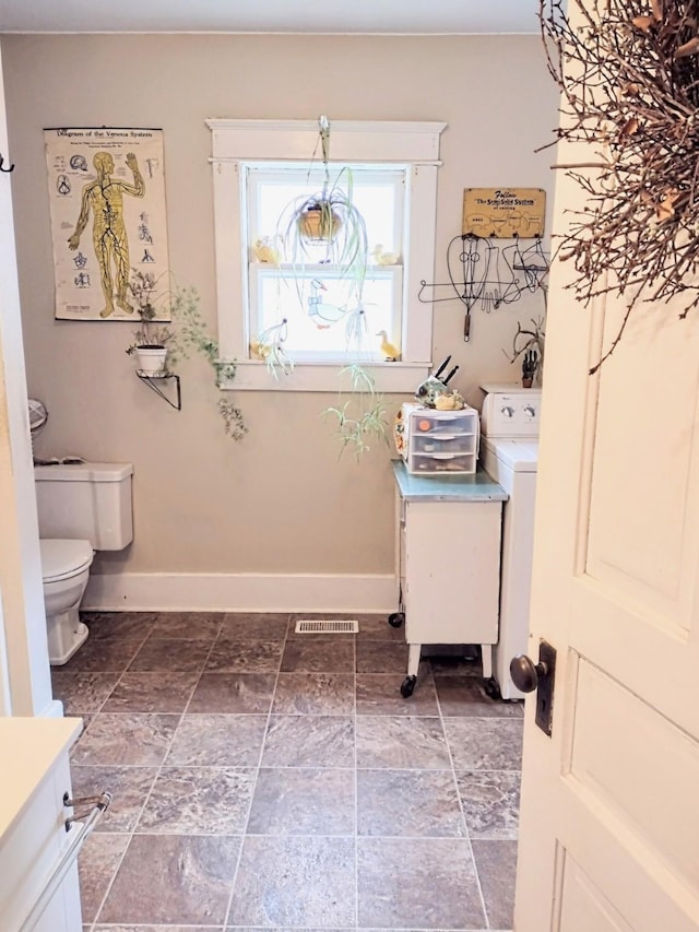 318 W Green St, Winterset, IA 50273 - laundry area with baseboards, washer / clothes dryer, and stone finish flooring