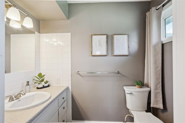 743 15th St, Nevada, IA 50201 - full bathroom featuring toilet, vanity, and backsplash