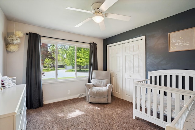 743 15th St, Nevada, IA 50201 - bedroom featuring carpet floors, a crib, a closet, baseboards, and a ceiling fan