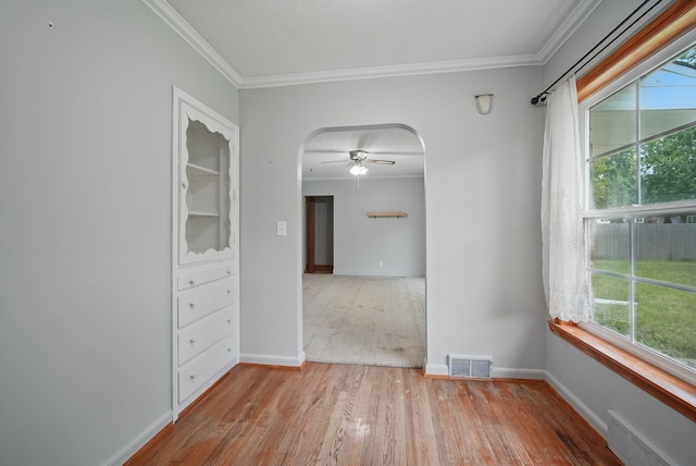 2620 Arnold Rd, Des Moines, IA 50310 - empty room featuring wood finished floors, arched walkways, ceiling fan, ornamental molding, and baseboards