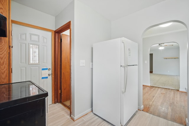 2620 Arnold Rd, Des Moines, IA 50310 - kitchen featuring freestanding refrigerator, arched walkways, light wood-style floors, and black electric range oven