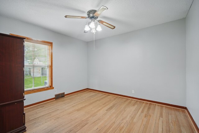 2620 Arnold Rd, Des Moines, IA 50310 - unfurnished room with wood finished floors, a ceiling fan, baseboards, and a textured ceiling