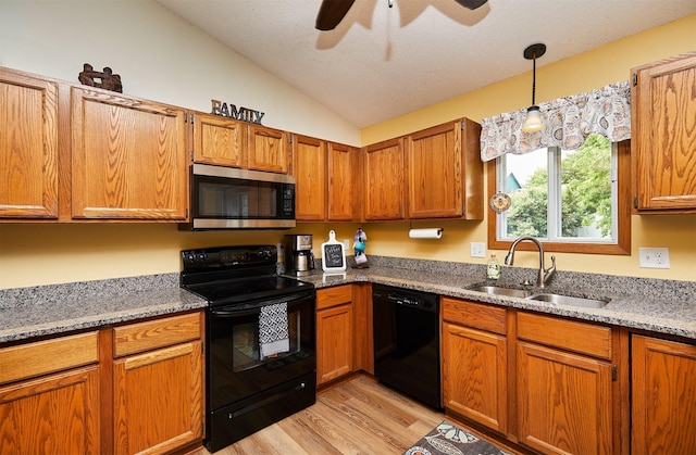 4230 SE 23rd St, Des Moines, IA 50320 - kitchen featuring black appliances, a sink, lofted ceiling, light wood-style flooring, and brown cabinets