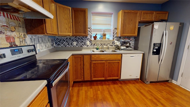1534 18th St, Des Moines, IA 50314 - kitchen featuring stainless steel appliances, under cabinet range hood, a sink, light wood-style flooring, and light countertops