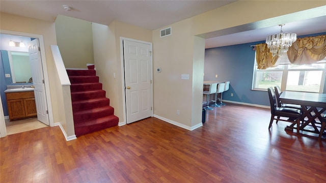 1534 18th St, Des Moines, IA 50314 - dining space with a chandelier, stairway, wood finished floors, and baseboards