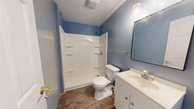 1534 18th St, Des Moines, IA 50314 - bathroom featuring wood finished floors, a shower, vanity, and toilet