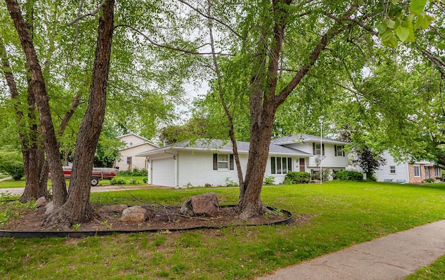 7405 Aurora Ave, Urbandale, IA 50322 - tri-level home with concrete driveway, a front lawn, and an attached garage