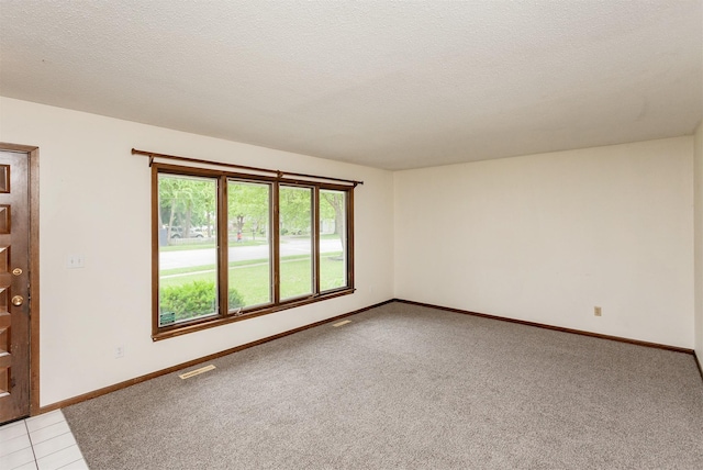 7405 Aurora Ave, Urbandale, IA 50322 - empty room featuring baseboards, light carpet, and a textured ceiling
