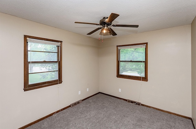 7405 Aurora Ave, Urbandale, IA 50322 - carpeted spare room featuring healthy amount of natural light, baseboards, ceiling fan, and a textured ceiling
