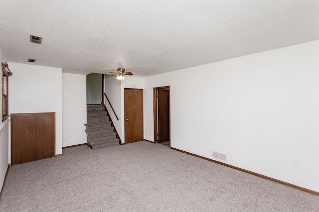 7405 Aurora Ave, Urbandale, IA 50322 - carpeted empty room with stairway, ceiling fan, a textured ceiling, and baseboards