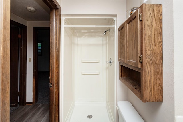 7405 Aurora Ave, Urbandale, IA 50322 - bathroom featuring a shower stall, wood finished floors, and toilet