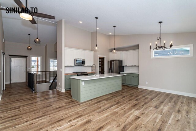 532 Wicker Dr, Huxley, IA 50124 - kitchen featuring stainless steel appliances, ceiling fan, white cabinets, high vaulted ceiling, and a sink