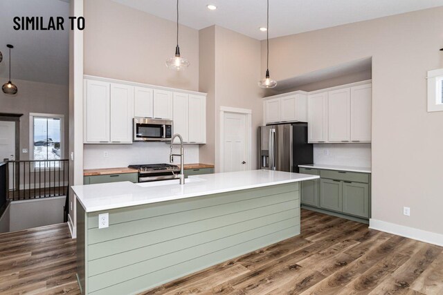 532 Wicker Dr, Huxley, IA 50124 - kitchen featuring stainless steel appliances, high vaulted ceiling, white cabinetry, a sink, and light countertops