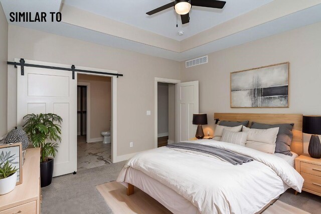 532 Wicker Dr, Huxley, IA 50124 - carpeted bedroom featuring a barn door, connected bathroom, baseboards, a tray ceiling, and ceiling fan