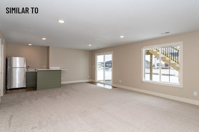 532 Wicker Dr, Huxley, IA 50124 - unfurnished living room featuring baseboards, carpet floors, and recessed lighting