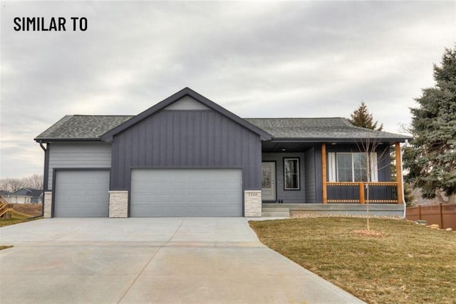 532 Wicker Dr, Huxley, IA 50124 - view of front of house featuring an attached garage, concrete driveway, covered porch, board and batten siding, and stone siding
