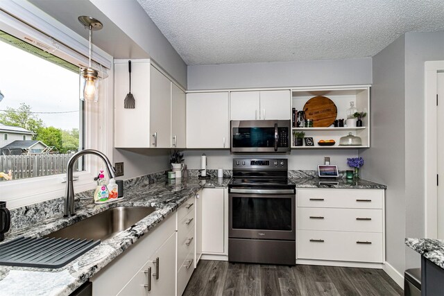 405 Joy Cir, Gilbert, IA 50105 - kitchen featuring appliances with stainless steel finishes, a sink, dark wood-type flooring, a textured ceiling, and light stone counters