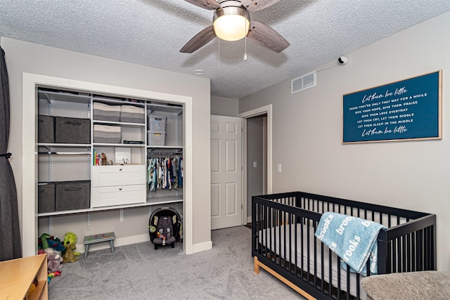 405 Joy Cir, Gilbert, IA 50105 - bedroom featuring carpet floors, a textured ceiling, a nursery area, a closet, and a ceiling fan