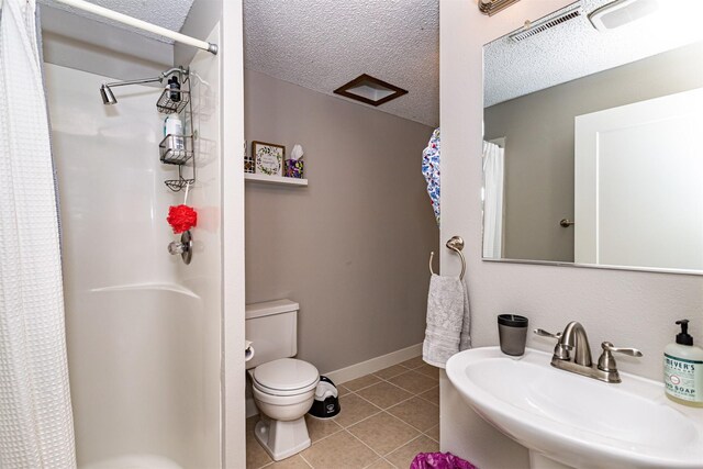 405 Joy Cir, Gilbert, IA 50105 - full bathroom featuring a sink, toilet, a shower with shower curtain, tile patterned floors, and a textured ceiling