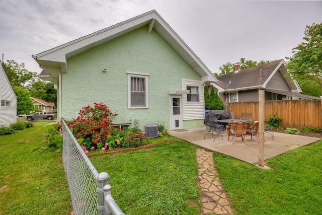 1058 40th St, Des Moines, IA 50311 - back of house featuring stucco siding, a patio area, and central AC