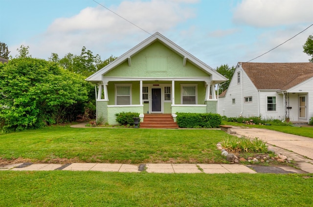 1058 40th St, Des Moines, IA 50311 - bungalow-style home with a porch, a front yard, and stucco siding