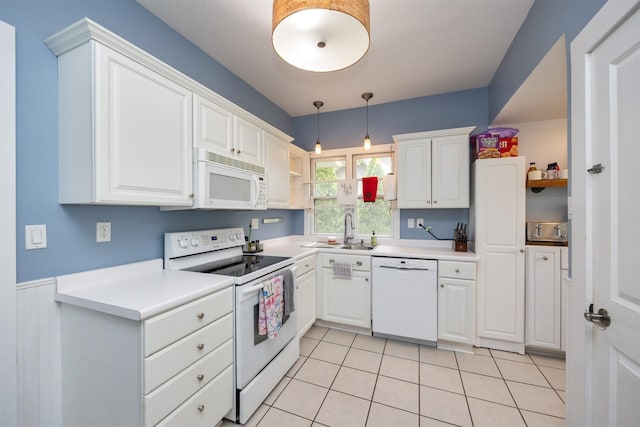 1058 40th St, Des Moines, IA 50311 - kitchen featuring white appliances, a sink, white cabinets, decorative light fixtures, and light countertops
