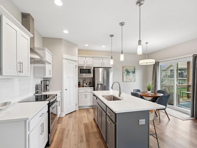 8876 Scarlet Dr, West Des Moines, IA 50266 - kitchen featuring appliances with stainless steel finishes, a sink, white cabinets, light wood-type flooring, and recessed lighting