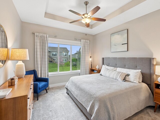 8876 Scarlet Dr, West Des Moines, IA 50266 - bedroom featuring carpet floors, a raised ceiling, baseboards, and a ceiling fan