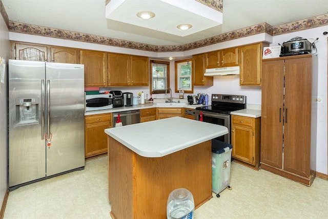 1212 8th Ave SE, Altoona, IA 50009 - kitchen featuring appliances with stainless steel finishes, light flooring, under cabinet range hood, a sink, and brown cabinets