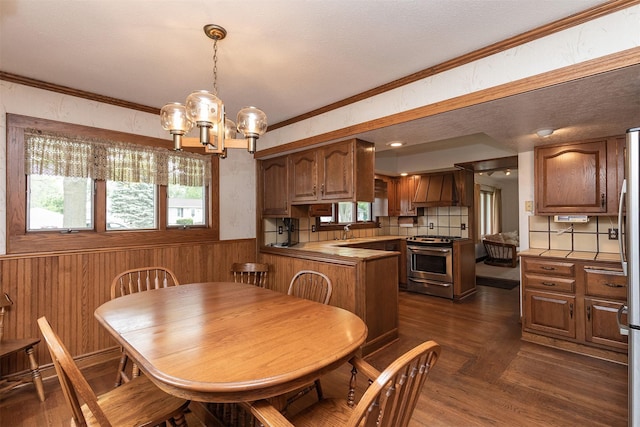 203 11th St, Dallas Center, IA 50063 - dining room featuring a chandelier, wainscoting, wood walls, ornamental molding, and a textured ceiling