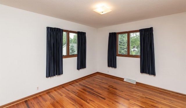 203 11th St, Dallas Center, IA 50063 - spare room featuring plenty of natural light, wood finished floors, and baseboards