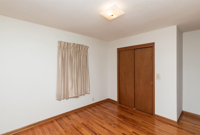 203 11th St, Dallas Center, IA 50063 - unfurnished bedroom featuring light wood-type flooring, baseboards, and a closet