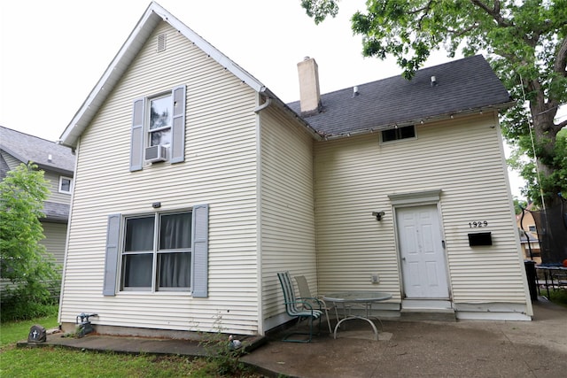 1929 10th St, Des Moines, IA 50314 - rear view of house featuring a patio, a chimney, and a trampoline