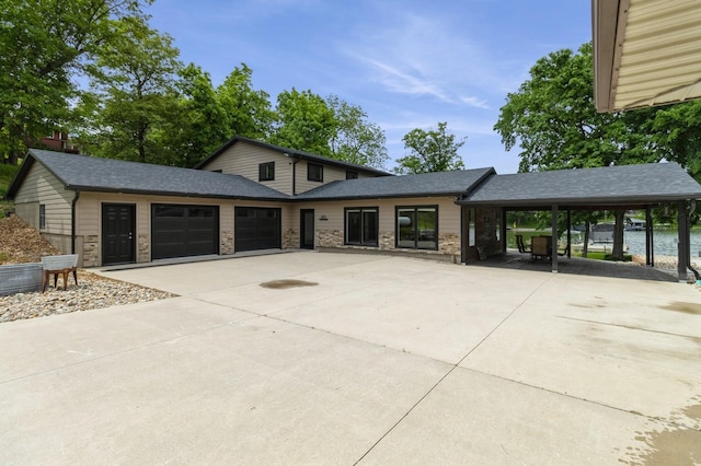 105 S Shore Dr, Montezuma, IA 50171 - view of front facade featuring concrete driveway, an attached garage, a carport, and roof with shingles