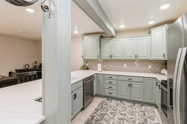 105 S Shore Dr, Montezuma, IA 50171 - kitchen with stainless steel appliances, gray cabinetry, decorative backsplash, recessed lighting, and light tile patterned floors