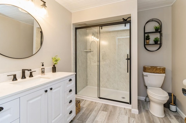 105 S Shore Dr, Montezuma, IA 50171 - bathroom featuring vanity, toilet, wood finished floors, a stall shower, and baseboards