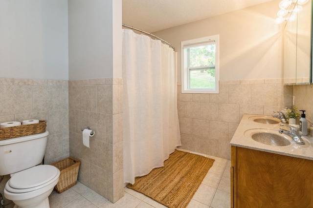 105 S Shore Dr, Montezuma, IA 50171 - full bathroom with tile walls, tile patterned floors, toilet, a wainscoted wall, and double vanity