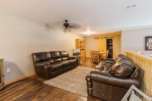 105 S Shore Dr, Montezuma, IA 50171 - living room with a barn door, a ceiling fan, dark wood-type flooring, and baseboards