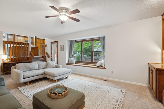 1645 NW 101st St, Clive, IA 50325 - living area with ceiling fan, light colored carpet, a textured ceiling, and baseboards