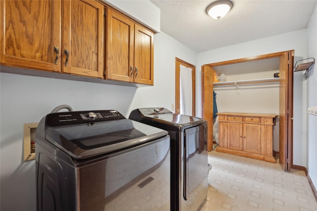 1645 NW 101st St, Clive, IA 50325 - laundry area with cabinet space, washer and dryer, a textured ceiling, baseboards, and light floors